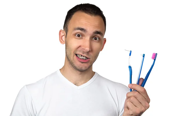 Foto van lachende man met haakjes en tandenborstel — Stockfoto