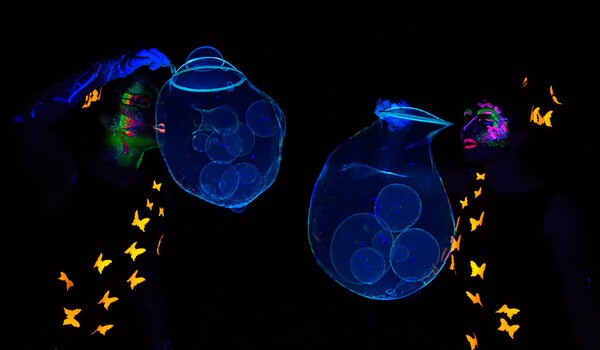 Photo of two women blowing luminous bubbles