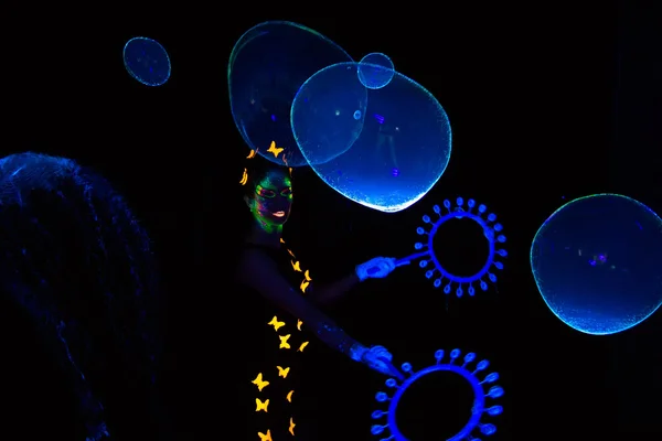 Фото женщины со светящимися мыльными пузырями — стоковое фото