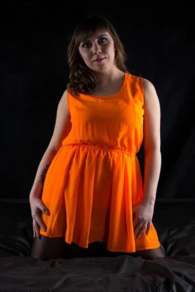 Foto einer molligen Frau in orangefarbenem Kleid — Stockfoto