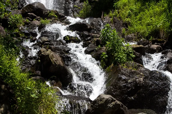 Photo waterfall among big dark stones — Stock Photo, Image