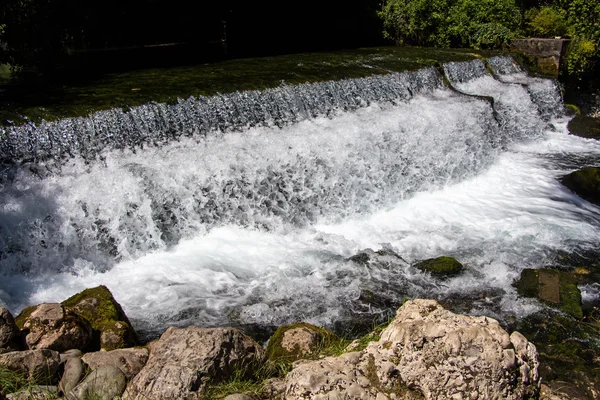 Photo of foaming flowing water among stones — Stock Photo, Image