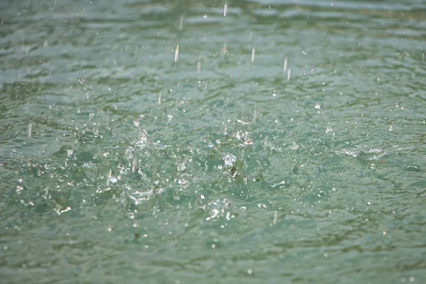 Kamera ışığı su yüzeyinde su sıçramalarına — Stok fotoğraf