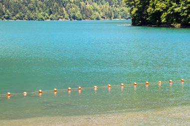 Photo of a clean mountain lake with buoys clipart