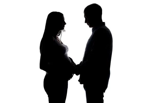 Silueta těhotné ženě a manžel drží za ruce — Stock fotografie