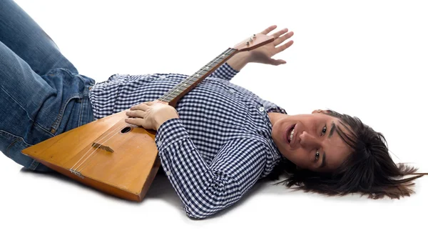 Liegender brünetter Mann mit Balalaika — Stockfoto