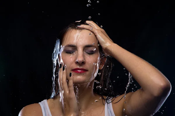 Young woman under running water Stock Photo