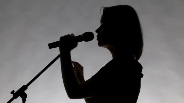 Genç kızın dinleyebilme ile siyah siluet — Stok video