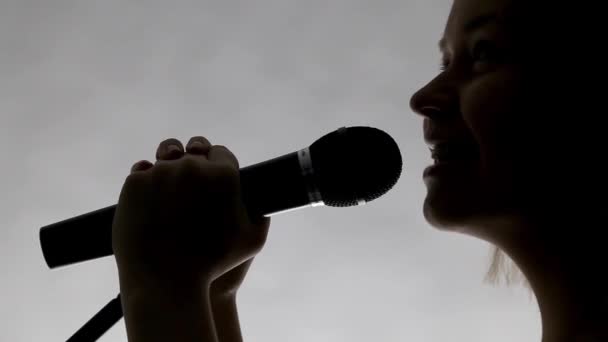 Силуэт девушки, поющей крупным планом — стоковое видео