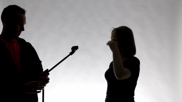 Silhouette bir kız ve adam dinleyebilme stand ile — Stok video