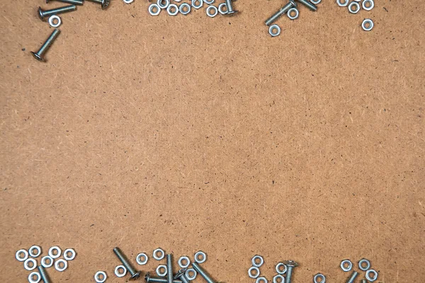 Iron bolts and nuts on fibreboard — Stock Photo, Image