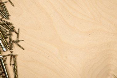 Soldaki tahta arka plan ile altın vidalar