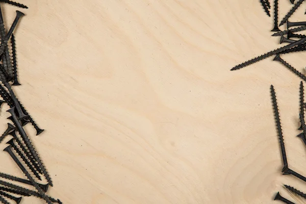 Schroeven links en rechts van de houten plaat — Stockfoto