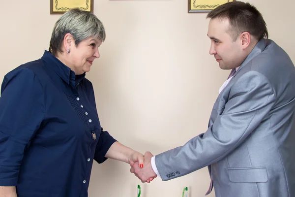 Two people in office shaking hands — Stock Photo, Image