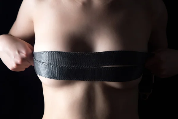 Kvinnans bröst med två remmar i mörkret — Stockfoto