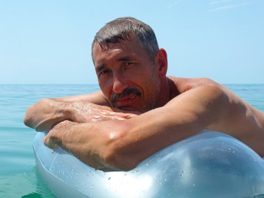 Yaşlı adam su yatağı üzerinde güneşlenme