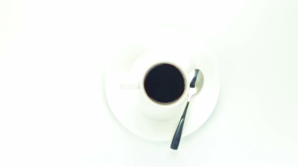 Taza de café con cuchara sobre fondo blanco — Vídeos de Stock