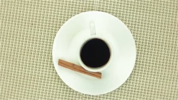 Чашка кофе с корицей на цветной салфетке — стоковое видео