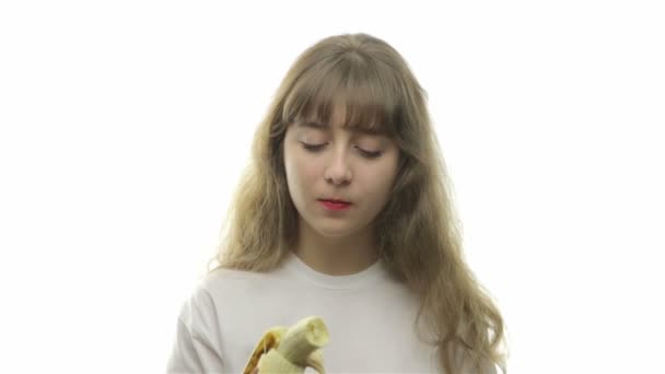Εφηβικό κορίτσι που δαγκώνει μακριά ώριμη μπανάνα — Αρχείο Βίντεο