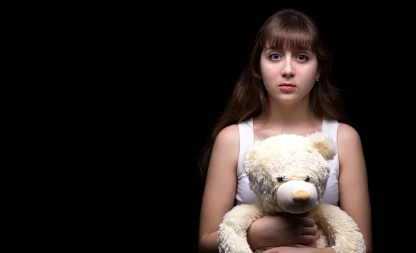 Scared blond teenage girl with teddy bear — Stock Photo, Image