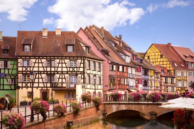 Colmar caddesindeki resim gibi manzara. Yarı ahşap evler, renkli mimari, kanal ve mavi gökyüzü. Seyahat güzergahı. Alsace, Fransa