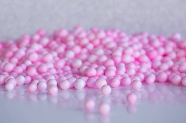 Bir sürü pembe toplar, pastel renkler soyut baloncuk arka planı. Sancak, kopyalama alanı, geometrik arkaplan. Modern teçhizat, gri yüzeye yansıyan çokça çözünmüş 3D toplar..