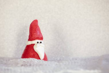 Kış arkaplanındaki komik Noel Baba figürü. Kırmızı, parlak Nicholas bebeği karlı arazide. Noel kartı, mevsimlik geçmiş..