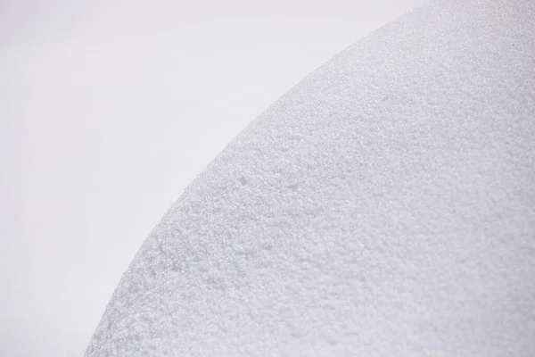 Snow curve background. Close up of snowdrift with visible texture, beautiful round shape line of pure snow wide shades of gradient.