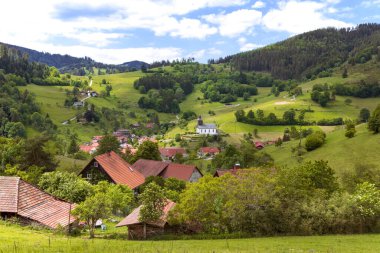 Idyll dağ manzarası, Almanya 'da kırsal yaz manzarası. Yeşil tepeler, mavi gökyüzü, orman, yeşil çayırlar ve vadideki küçük köy. Schwarzwald, Almanya. Kara Orman.