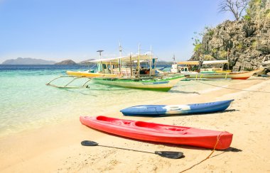 Longtail tekneler ve kayaklar Coron Palawan - Filipinler - doğa güzellikleri dünya çapında seyahat kavramı - sıcak güneşli öğleden sonra renk tonları güzel tropikal hedef ile beyaz kum plaj