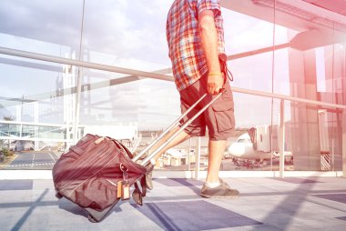 Gezgin adam Uluslararası Havalimanı terminal kapısına uçak için hareketli bacak ve çanta üzerinde bulanık hareket - solo kişi üstünde belgili tanımlık gitmek ile yolculuk tutkusu kavramı - Rose kuvars filtre halo ile odak seyahat