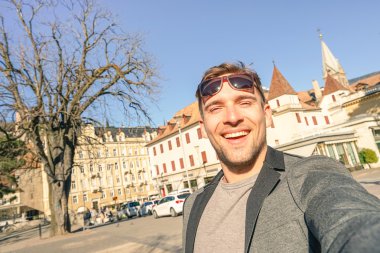 Yakışıklı delikanlı Meran eski şehirde eğik ufuk ve sıcak öğleden sonra renk tonları ile İtalya - Avrupa hedef etrafında seyahat ve macera yaşam tarzı - bileşiminde South Tyrol, selfie alarak