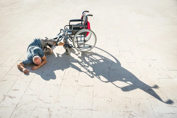 Niepełnosprawny mężczyzna z handicapem po wypadku wypadek z wózka inwalidzkiego - koncepcja niepełnosprawności z bezsilni unhelped osobie leżącej na podłodze - zagadnienia społeczne z nieprawidłową facet na difficultes — Zdjęcie stockowe