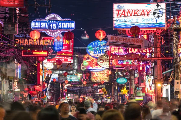 PATTAYA, TAILANDIA - 18 DE FEBRERO DE 2016: letreros de neón multicolores y personas borrosas en la nueva calle peatonal de la ciudad - La carretera está cerrada al tráfico después de las 6 pm y permanece llena hasta altas horas de la noche —  Fotos de Stock