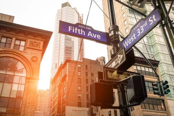 第五大道和西第 33 届圣在日落时在纽约城-曼哈顿市中心城市概念和道路方向-美国世界著名资本目的地上温暖筛选看起来更加生动的街头标志 — 图库照片
