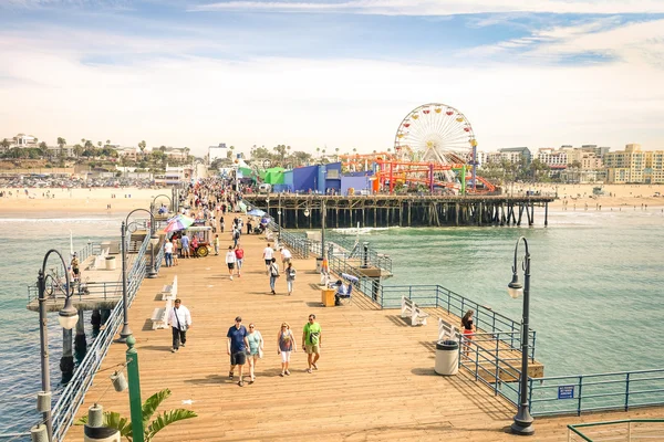 LOS ANGELES - 18 MARCH 2015: high angle view of international tourists and local people at Santa Monica Pier with ferris wheel of Pacific Amusement Park - Famous american landmark on californian coast — Stock Photo, Image