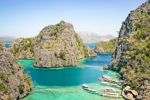 Blue lagoon with longtail boats by Karangan Lake in Coron Palawan - Beautiful tropical destination in Philippines - Travel concept to nature wonders around the world - Warm sunny afternoon color tones — Stock Photo, Image