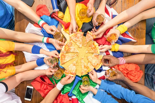 Vista superior de las manos multiétnicas del partidario del deporte de fútbol compartiendo pizza margherita - Concepto de amistad con los aficionados al fútbol disfrutando de la comida juntos - La gente comiendo en el bar del partido después del evento del partido deportivo — Foto de Stock