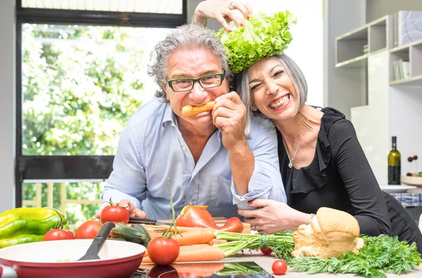 depositphotos 111110442 Senior couple having fun in kitchen with healthy food Retired people cooking meal at home with man and woman preparing lunch with bio vegetables Happy elderly concept with mature funny pensioner