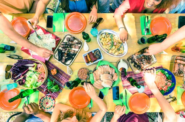 Vista superior de manos amigas que sirven comida en la fiesta del jardín de barbacoa - Grupo de personas multirraciales que disfrutan de la comida a la parrilla en la reunión de barbacoa del patio trasero - Almuerzo y concepto de cena al aire libre - Filtro cruzado vívido — Foto de Stock