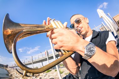 Genç adam performans gösteren trompet solo caz beach parti - müzik ve açık hava kulübü yeri groove ruh atmosferi ile sokak sanatı kavramı - sıcak öğleden sonra renk tonları müzisyen yüz odaklı