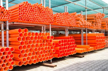 Turuncu pvc su boruları terk edilmiş endüstriyel alanda - inşaat kavramı ile site oluşturma, plastik ekipman yığın yığını