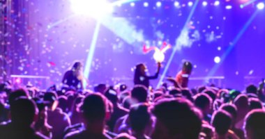 Müzik gecesi festivalinde dans eden bulanık insanlar - Lazer şovlu disko kulübünün soyut arkaplan görüntüsü - Gece hayatı eğlence konsepti - Kontrast menekşe filtresi