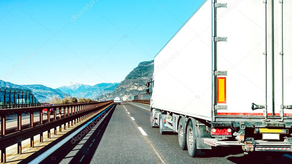 Semi truck speeding on empty highway line - Transport logistic concept with semitruck container driving on speedway - Focus on central part of background