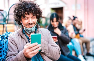 Hipster 'ın cep telefonundan haber izlemesi üniversite öğrencilerinin üniversite molasında eğlenmesi parlak, canlı bir filtre.