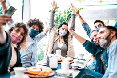 Mutlu arkadaşlar kahve barında yüz maskesi takarak selfie çekiyorlar - Yeni normal yaşam tarzı ve restoran kafede eğlenen gençlerle konsept topluyorlar - parlak gök mavisi filtresi