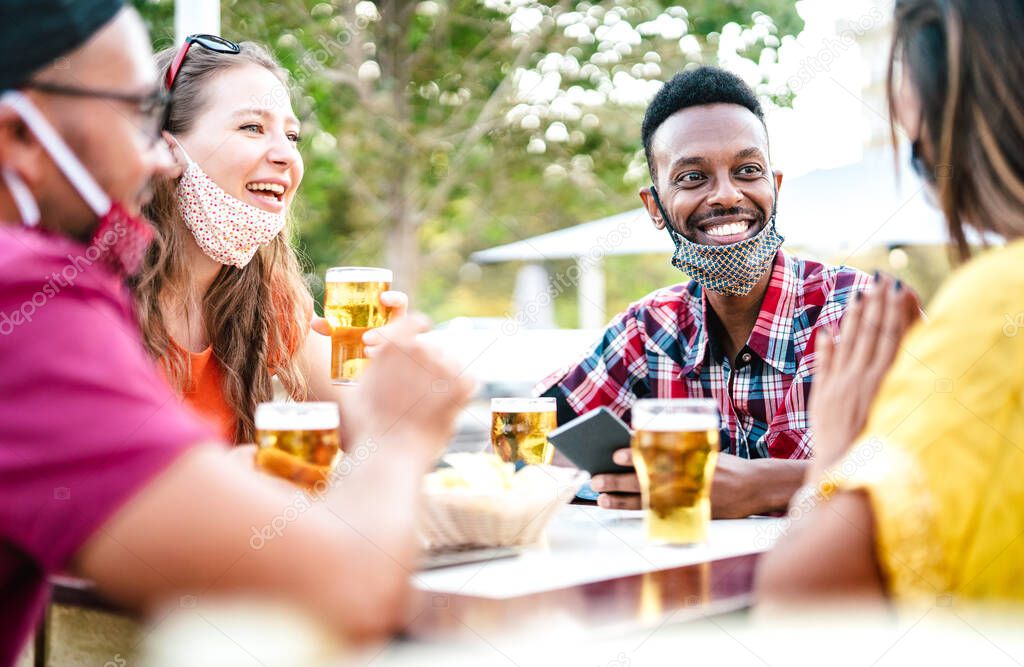 Multicultural people drinking beer with open face masks - New normal gathering concept with friends having fun together on happy hour at brewery bar - Bright filter with focus on afroamerican guy