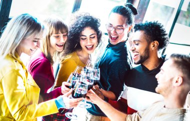 Genç çok ırklı insanlar akşam yemeği partisinde kırmızı şarap içiyor ve kadeh kaldırıyor mutlu sarhoş arkadaşlar restoran şaraphanesinde birlikte eğleniyor parlak arka plan filtresi üzerinde yaşam tarzı konsepti oluşturuyorlar.