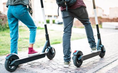 Şehir parkında elektrikli scooter kullanan şehir sakinlerinin kapatılması - Yeni modern ekolojik ulaşım aracına binen milenyum öğrencileri - sıfır emisyonlu yeşil ekolojik enerji kavramı - parlak retro filtre