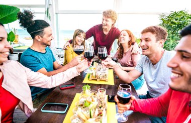 Mutlu milenyum insanları özel ev partisinde şarap içerek eğleniyor. Genç arkadaşlar restoranın yeniden açılışında parmak yemeği yiyorlar.